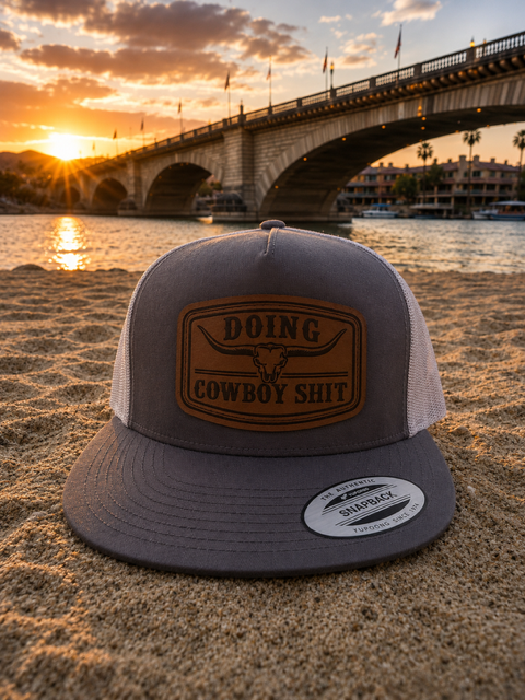 Grey trucker hat with leather longhorn patch on the beach at London Bridge