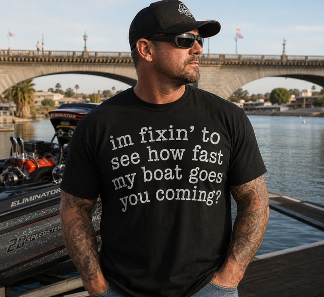 Man wearing a black Fixing To Go Fast t-shirt beside a performance boat at London Bridge in Lake Havasu City