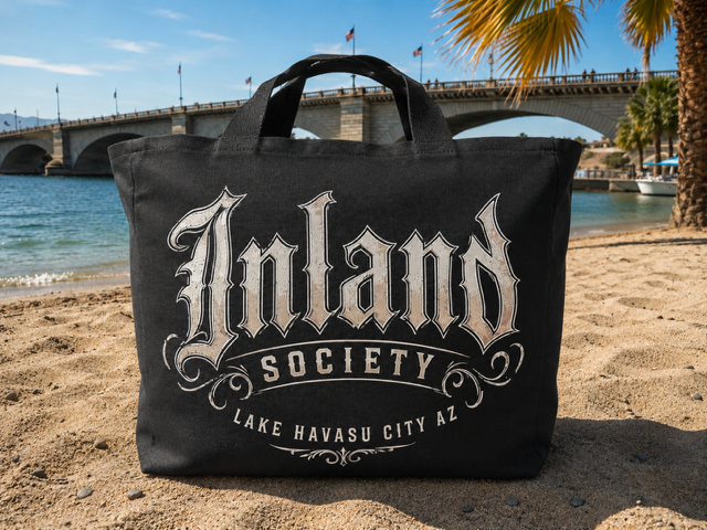 Black Inland Society canvas tote bag on the beach